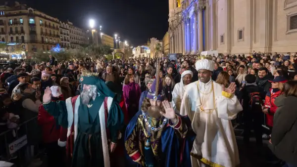 La cabalgata Miralbueno ilumina la noche con los Reyes Magos saludando a la multitud.