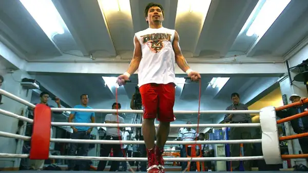 Boxers jump rope to build stamina and footwork. Manny Pacquiao trains in a boxing ring, surrounded by spectators.