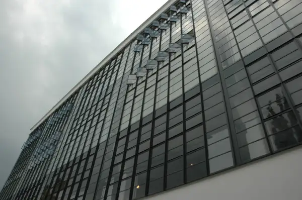 Szklana fasada budynku, przykład modernizmu. Charakterystyczne okna wychylne tworzą ciekawy wzór.