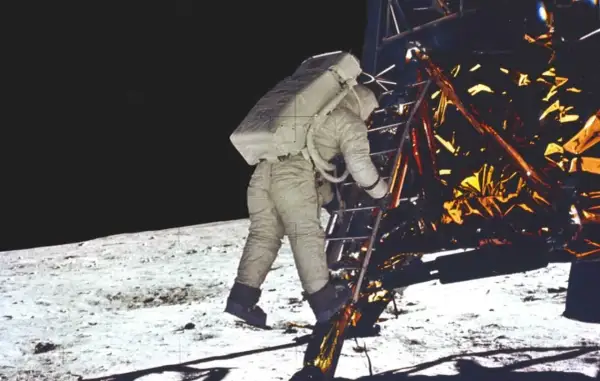 Astronaut schodzi po drabinie modułu księżycowego, rozpoczynając historyczne lądowanie na księżycu.