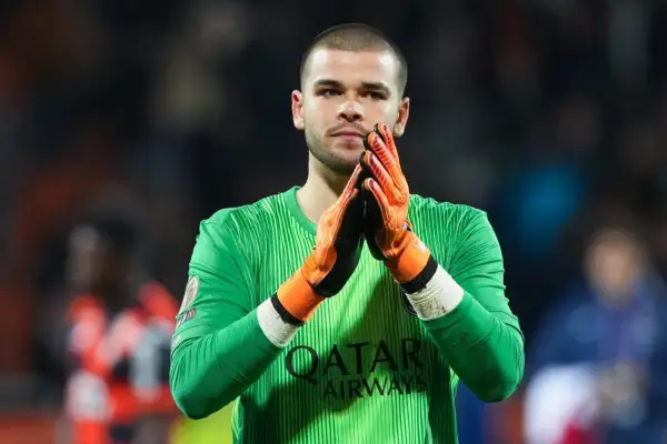 Bramkarz PSG w zielonej koszulce z pomarańczowymi rękawicami, z dłońmi złożonymi do oklasków.