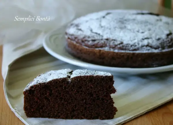 Una fetta di torta con kefir e cacao, spolverata di zucchero a velo, su un tovagliolo.