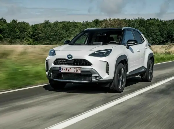 Biały Toyota Yaris Cross na drodze, idealny do miasta i na wakacje. Sprawdź nasze toyota yaris cross opinie!