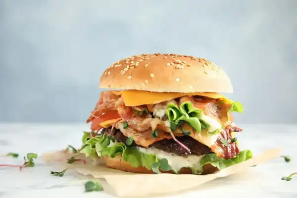 Apetyczny burger z bekonem, serem i warzywami. Zastanawiasz się nad big mac kcal? Ten burger wygląda na sycący!