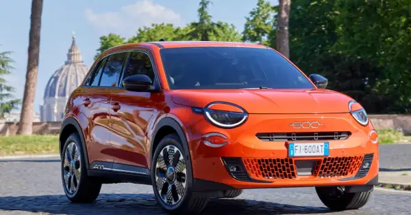 Pomarańczowy Fiat 600 na tle rzymskiej kopuły. Sprawdź atrakcyjną fiat 600 cena!