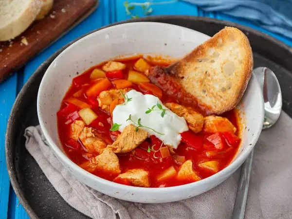 En värmande kyckling soppa med paprika, potatis och en klick gräddfil. Serveras med rostat bröd.
