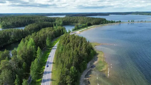 Malownicze jeziora i lasy Finlandii. Droga wije się wśród zieleni, idealna na podróż, by odkryć, co zobaczyć w Finlandii.