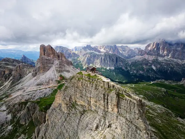 Un refuge de montagne perché sur un pic rocheux, au cœur des Dolomites en Italie. Un paysage spectaculaire de montagnes escarpées et de vallées verdoyantes.