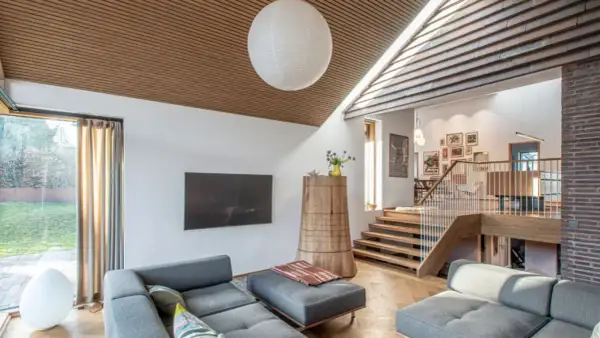 Gemütliches Wohnzimmer in einem Split-Level-Haus mit Holzakzenten, Treppen und gemütlichen Sofas.