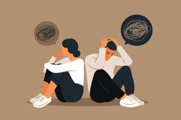 Twee mensen zitten rug aan rug, met hun hoofd in hun handen. Ze voelen zich verloren en alleen, alsof ze je niet thuis voelen bij je familie.
