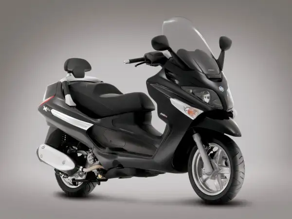 Elegancki, czarny Piaggio X9 250 z wygodnym siedzeniem i dużym przednim wiatrochronem, gotowy na miejskie podróże.