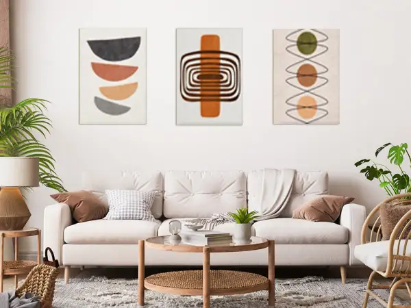 Trzy obrazy w formacie 30x40: geometryczne półkola, spirale i kółka. Nowoczesny salon z sofą i stolikami.