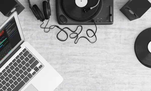 Laptop z programem do edycji dźwięku, gramofon, słuchawki i płyty winylowe. Tworzenie muzyki, sample co to?
