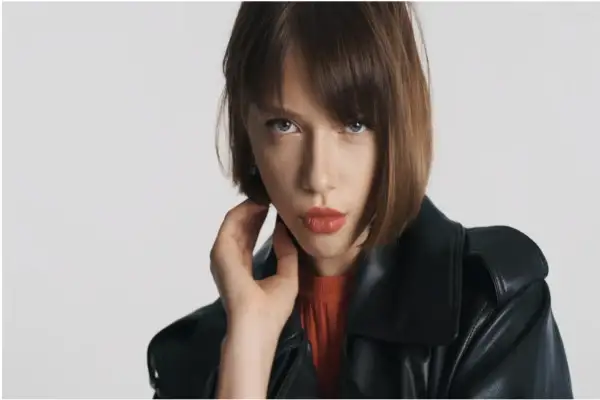 Mujer con un moderno corte bob, labios rojos y chaqueta de cuero negra.