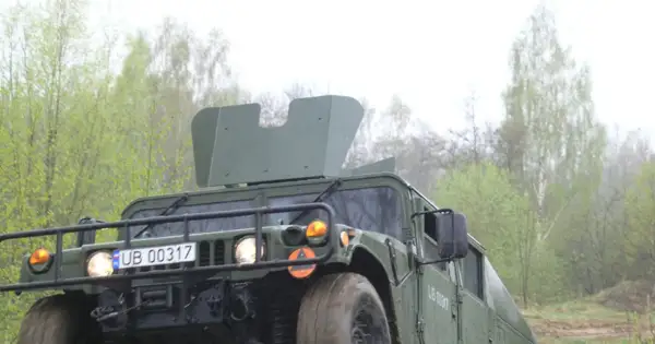 Zielony humvee z tablicą rejestracyjną UB 00317 jedzie przez las.