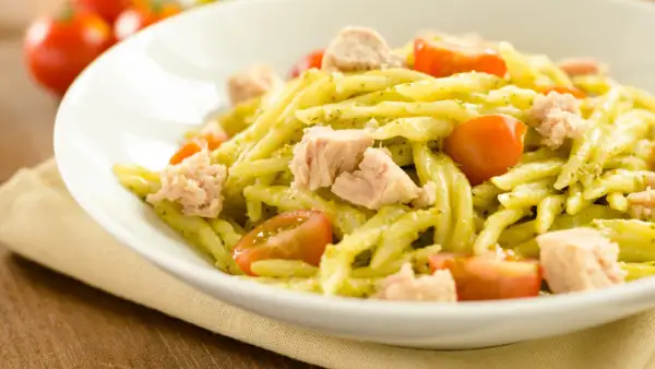 Pasta fredda al pesto con tonno e pomodorini, un piatto estivo fresco e saporito.