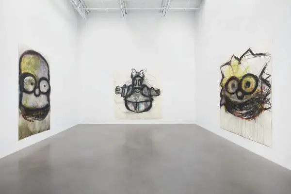 Gallery space with three expressive, cartoon-like portraits by Joyce Pensato.