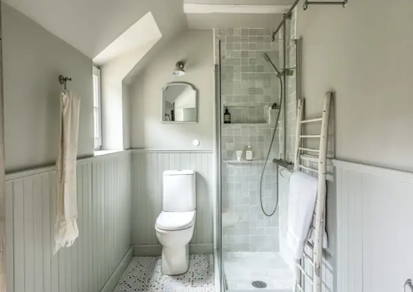 Douche, WC et lavabo dans une petite salle de bain 3m2. Un style épuré et fonctionnel avec des carreaux gris et un mur lambrissé.