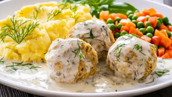 Pyszne pulpeciki w kremowym sosie, podane z puree ziemniaczanym i warzywami. Idealny pomysł, jak zrobić sos do pulpetów, by danie było wyborne!