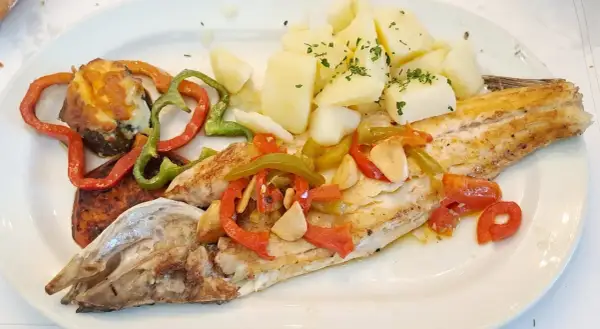 Lubina a la bilbaina con patatas y pimientos asados. Un plato delicioso y saludable.