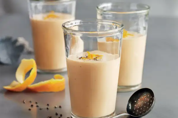 Tre glas med krämig apelsinsmoothie, toppad med rivet apelsinskal och pepparkorn. Ett perfekt smoothie recept för en uppfriskande start.