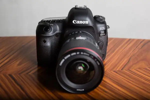 Profesjonalny aparat Canon EOS 5D Mark IV na drewnianym stole. Dowiedz się, jak sprawdzić przebieg migawki Canon.
