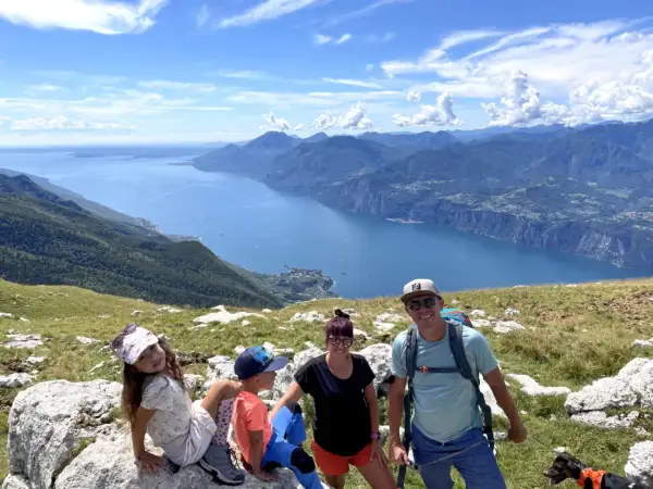 Rodzina z psem cieszy się widokiem na jezioro Garda z Monte Baldo.
