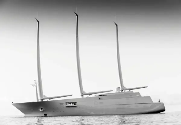 Un maestoso yacht a vela, un'opera di design firmata Philippe Starck, solca le acque con le sue tre imponenti vele.