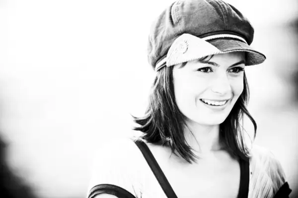 Sorriso contagioso di Lisa Lelli con un cappello alla marinara, in un ritratto in bianco e nero.