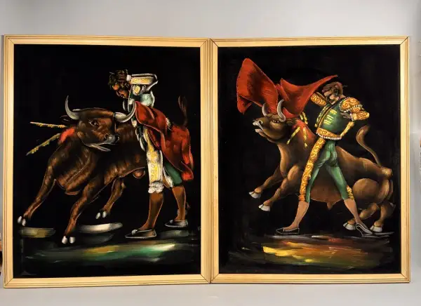 Two paintings by 1970s artists painters depict matadors facing bulls. The vibrant velvet art captures the drama of the bullfight.