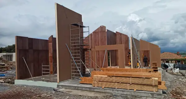 Construcción de casas entramado ligero con paneles prefabricados de madera. Andamios y materiales listos para seguir levantando las estructuras.