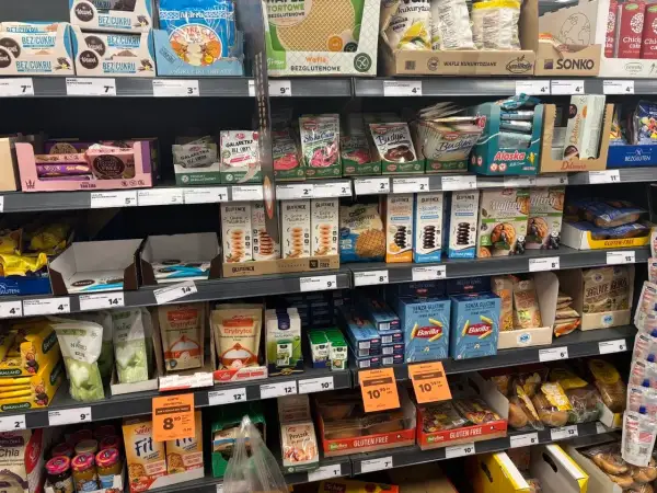 Półka z produktami bezglutenowymi: wafle, ciastka, muffiny, makarony i inne.