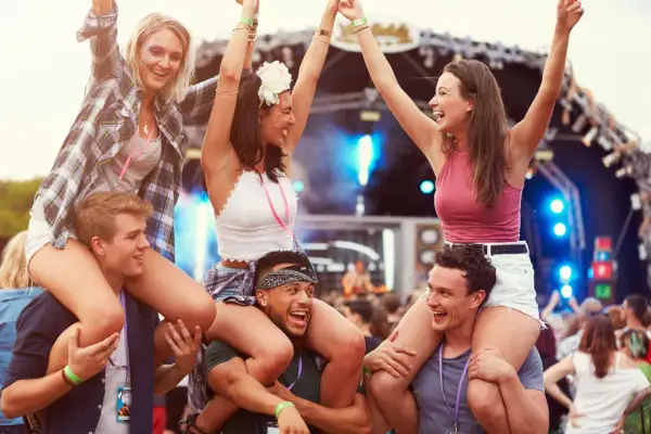 Radosna ekipa na jednym z corocznych festiwali w Polsce. Dziewczyny siedzą na barana, bawiąc się przy muzyce.
