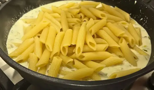 Smażony makaron penne w kremowym sosie z ziołami, gotowy do podania.