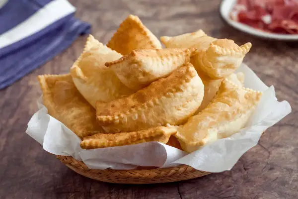 Cesto di gnocco fritto modenese dorato e soffice, pronto per essere gustato con salumi.