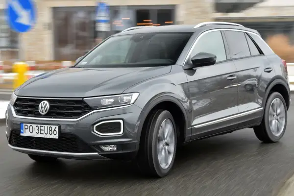 Szary Volkswagen T-Roc w ruchu miejskim. Wiele osób szuka volkswagen t-roc opinie, by podjąć decyzję o zakupie.