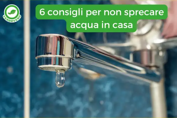 Goccia d'acqua che cade da un rubinetto cromato, simbolo di spreco d'acqua in casa.