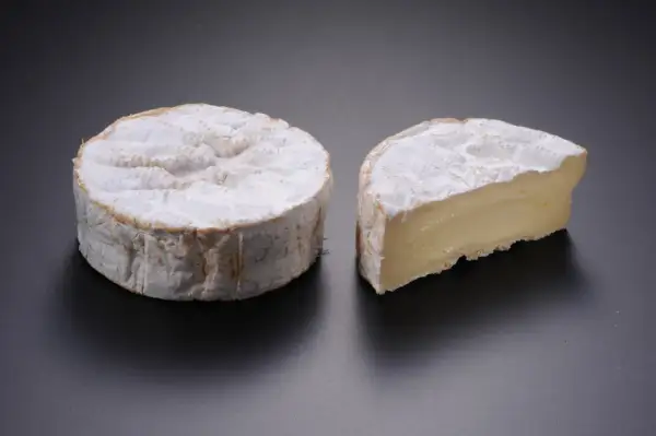 Deux camemberts, l'un entier, l'autre coupé, évoquant le top 10 des fromages les plus connus au monde.