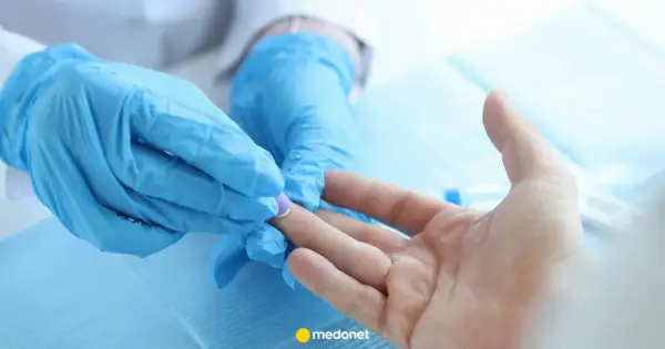Rękawiczki medyczne pobierają próbkę krwi z palca do badania CRP. Wynik wskazuje na CRP norma.