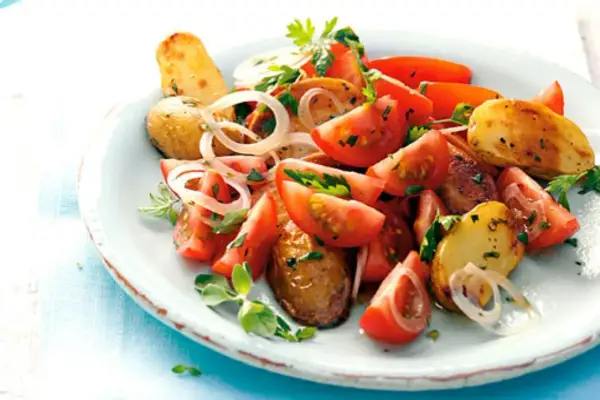 Tomaten-Kartoffel-Salat mit Zwiebeln und Kräutern, ein Beispiel für die vielseitige Majoran verwendung.