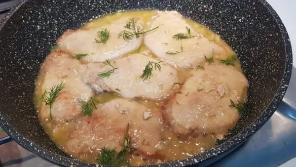Scaloppine di maiale in padella con un sughetto dorato e finocchietto fresco.