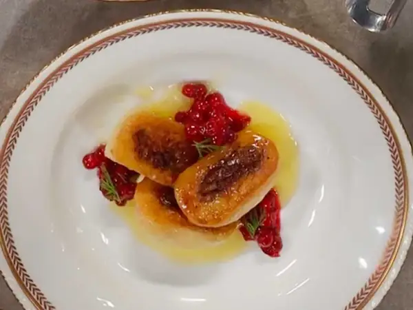 Tre gyllene kroppkakor serveras med lingon och en ljus sås. Ett vackert recept på kroppkakor!