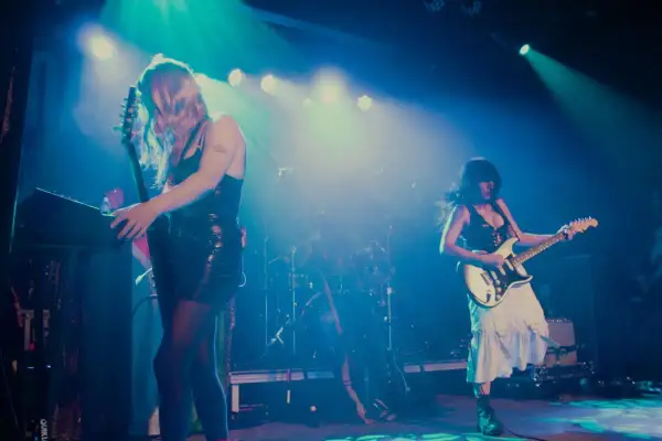 Mannequin Pussy rocks the stage, with one guitarist playing a keyboard and the other shredding a white electric guitar.
