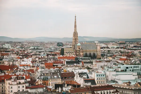 Ein atemberaubender Blick auf Wien von oben. Der Stephansdom mit seinem markanten Turm und dem bunten Dach dominiert die Stadtansicht.