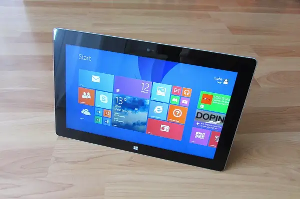 Tablet z interfejsem Windows 8, widok z góry, na drewnianym blacie.