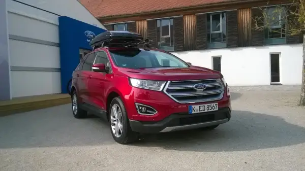 Czerwony Ford Edge z boxem dachowym, idealny na rodzinne wyjazdy. Sprawdź jego imponujące ford edge wymiary!
