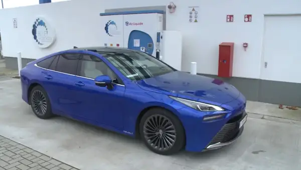 Niebieska Toyota Mirai na stacji tankowania wodoru. Sprawdź aktualną toyota mirai cena i ekologiczną przyszłość motoryzacji.