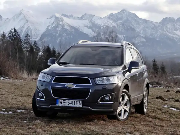 Chevrolet Captiva na tle górskich szczytów. Wiele osób szuka chevrolet captiva opinie, by sprawdzić, czy ten SUV sprawdzi się w trudnym terenie.