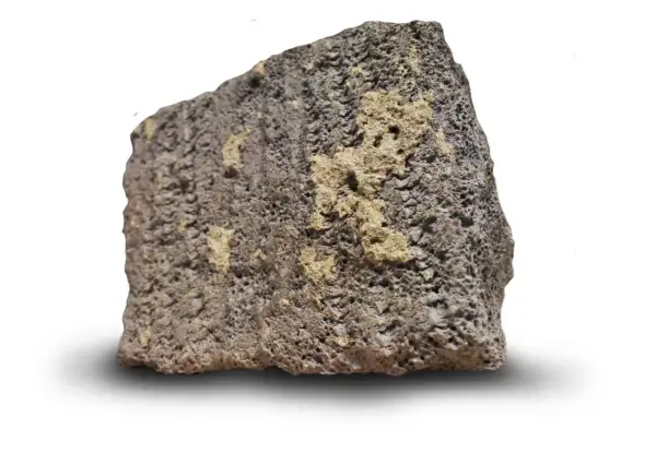 En bit porös, mörkgrå sten med ljusare gula partier. Så här ser blåbetong ut, en lätt och isolerande sten.