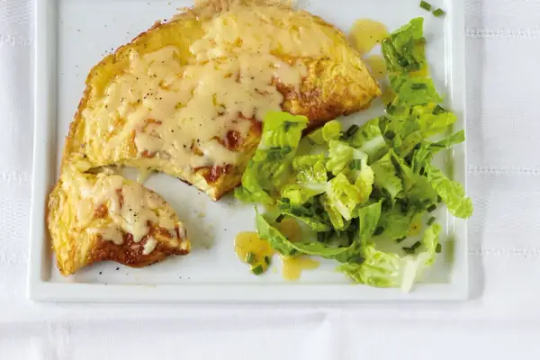 Ein herzhaftes Omelett mit geschmolzenem Käse, serviert mit einem frischen Salat. Perfekt für ein schnelles Omelette Rezept.